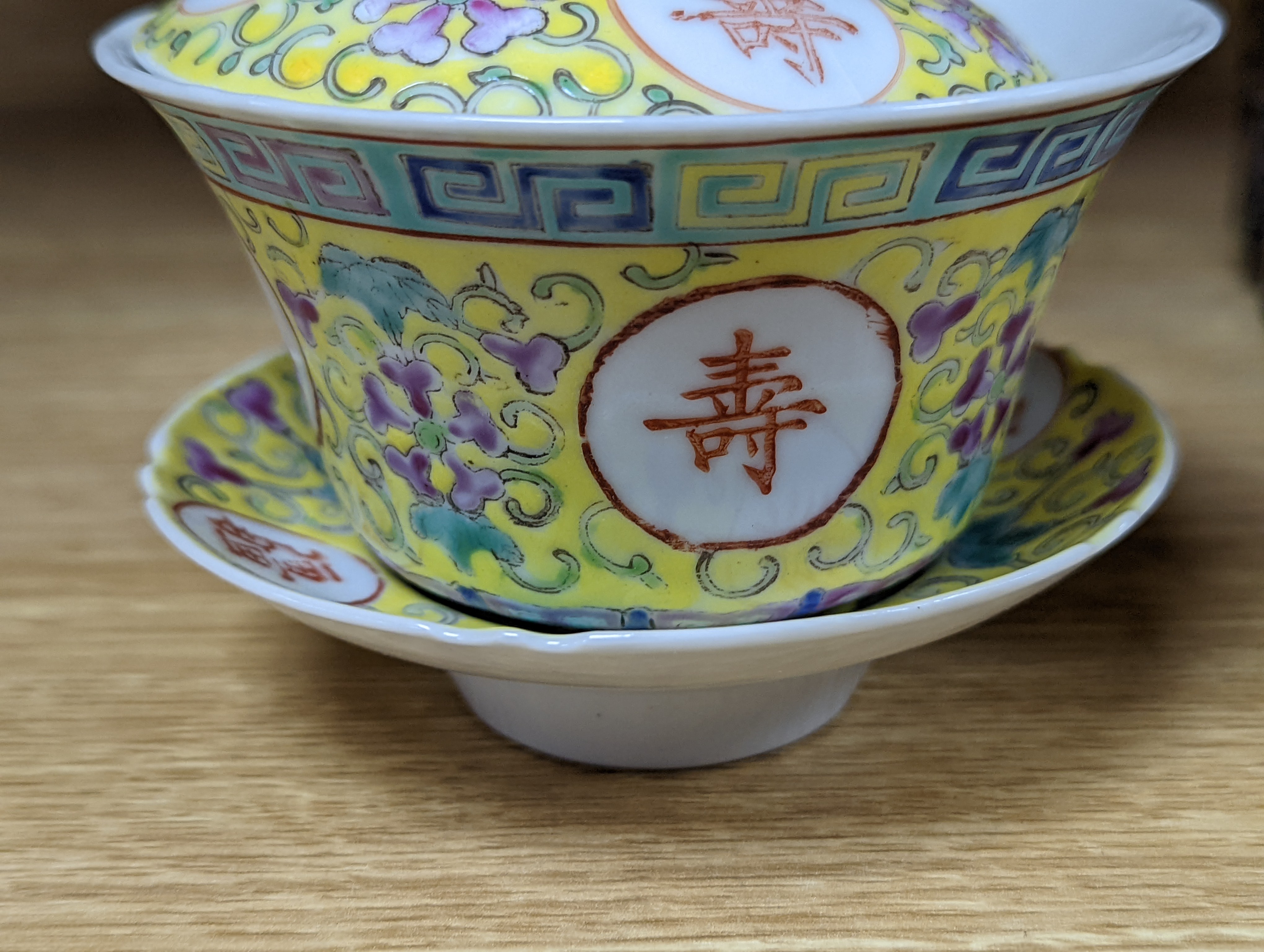 A pair of Chinese enamelled porcelain rice bowls, covers and stands and an odd bowl